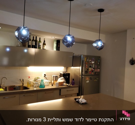 מנורות תלויות מעל אי במטבח מואר